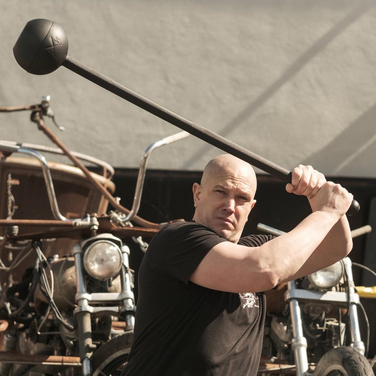 A man mid-swing with a Bells of Steel Adjustable Macebell, the round ball head trailing behind the shaft