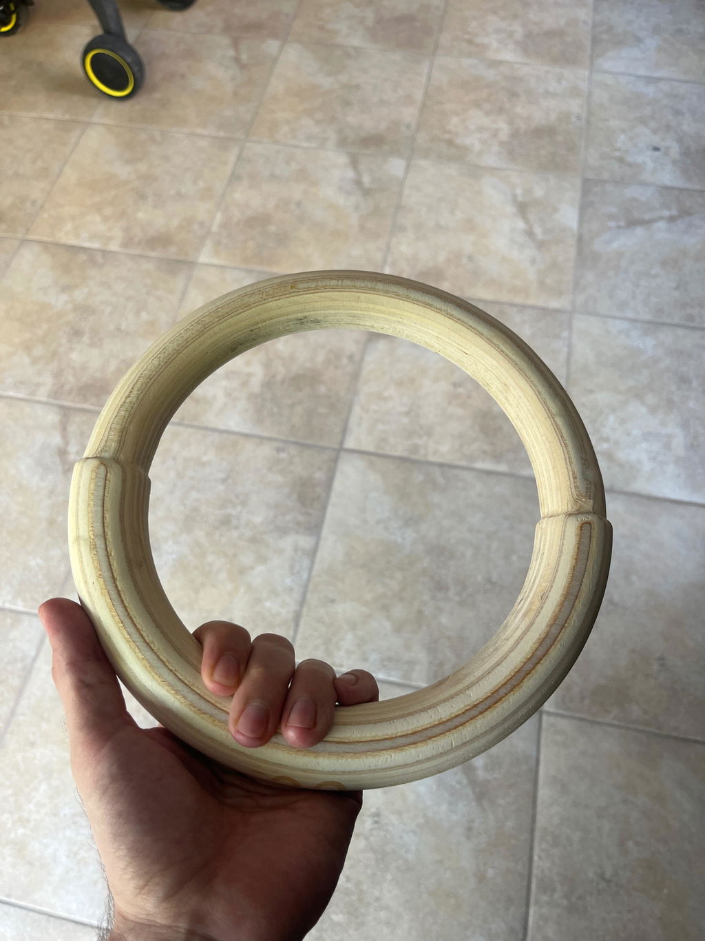 Wooden gymnastic ring held in one hand