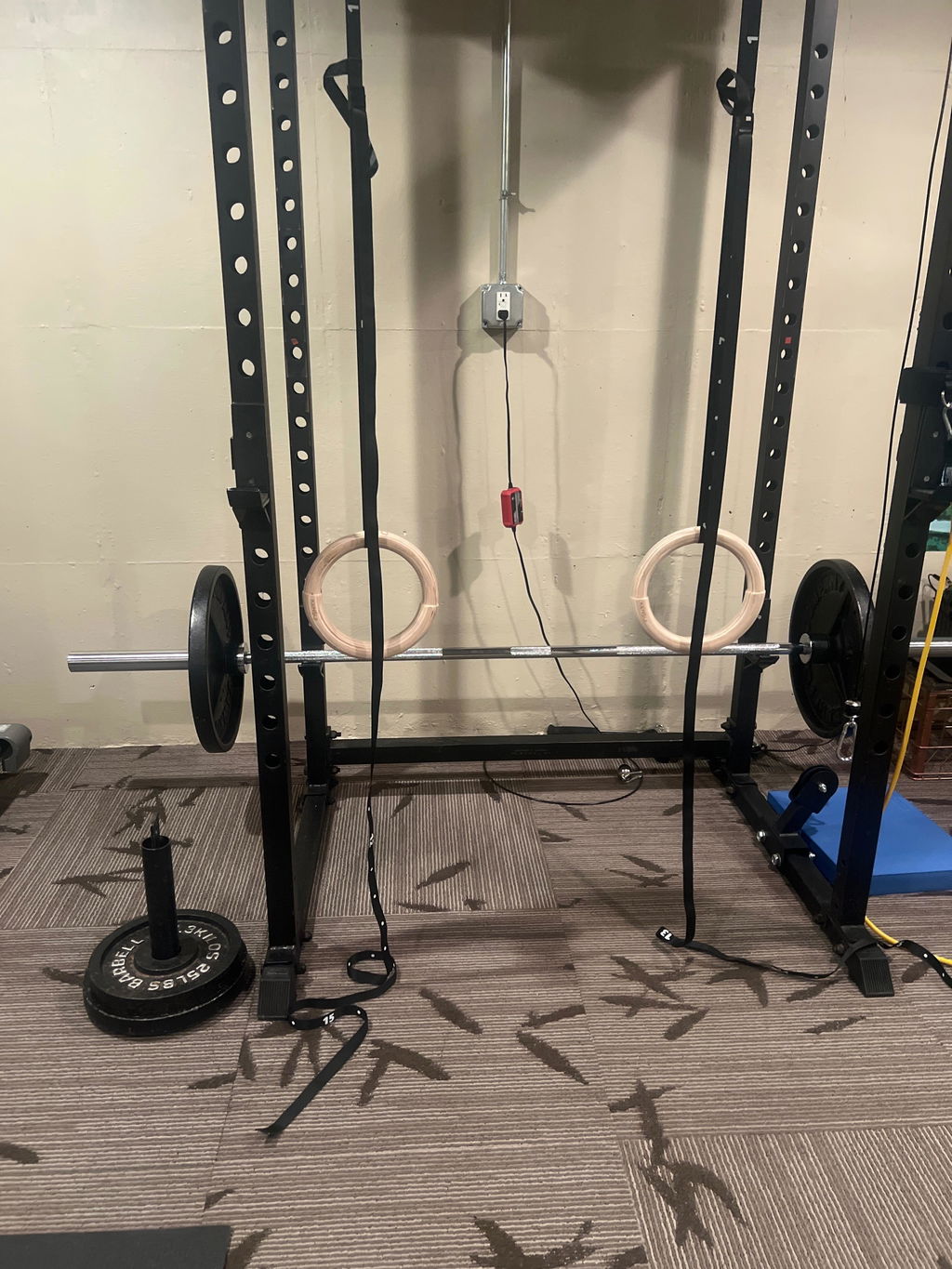 Wooden rings hanging from a garage gym rack