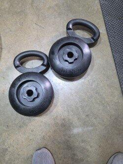 Two EZ-BELL handles with plates loaded, photographed on a garage floor