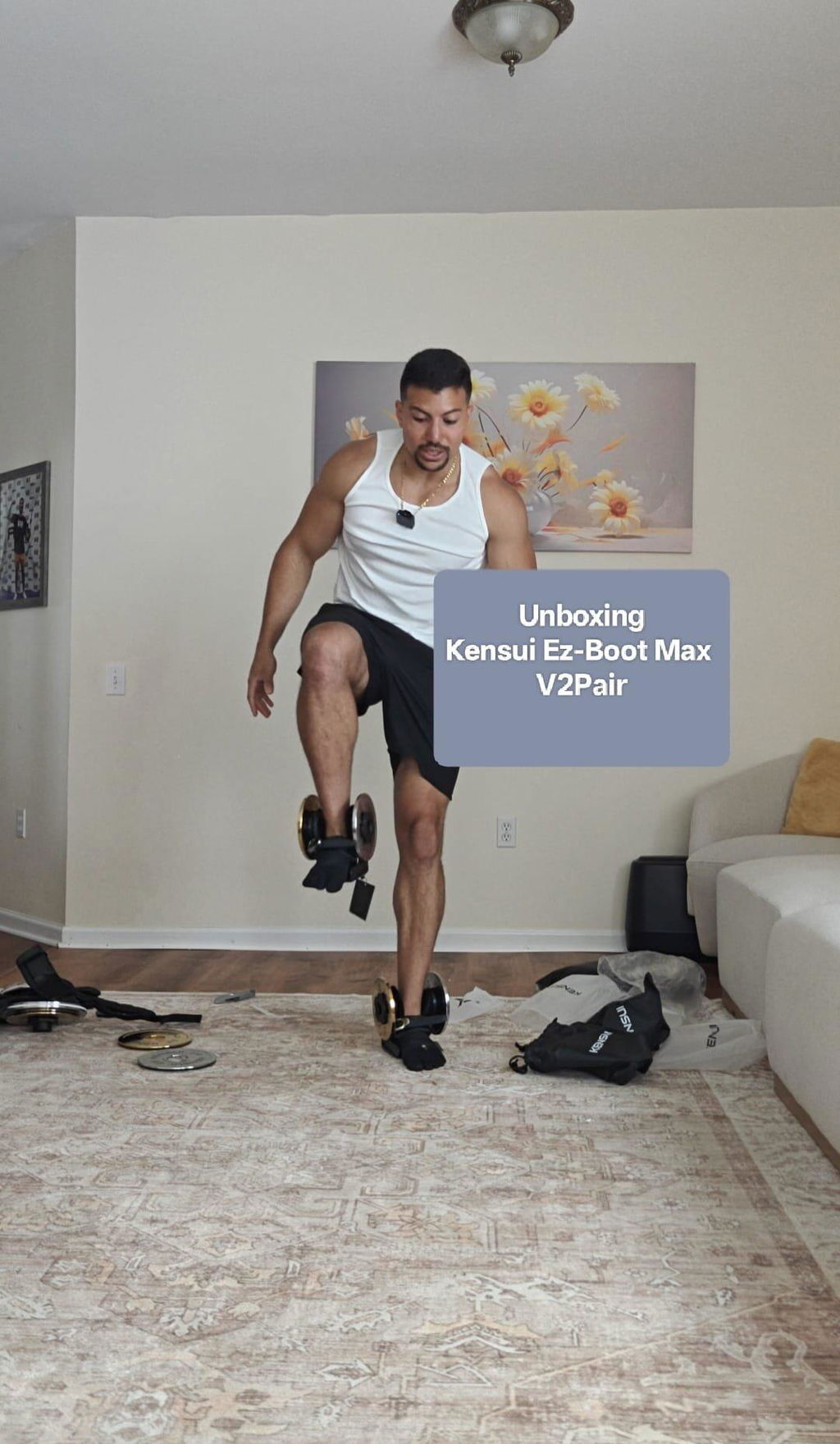 A man doing a standing loaded leg raise at home wearing plate-loaded boots on both feet