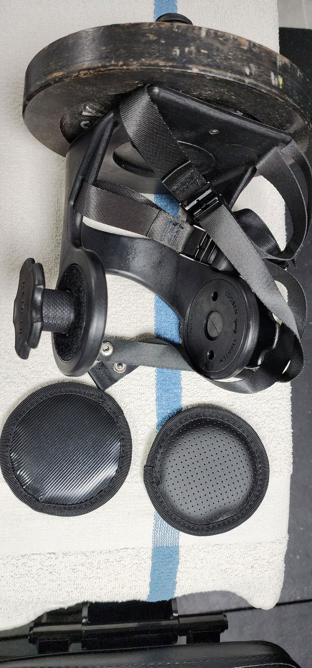 A single plate-loaded training boot on a towel with two smaller plates beside it