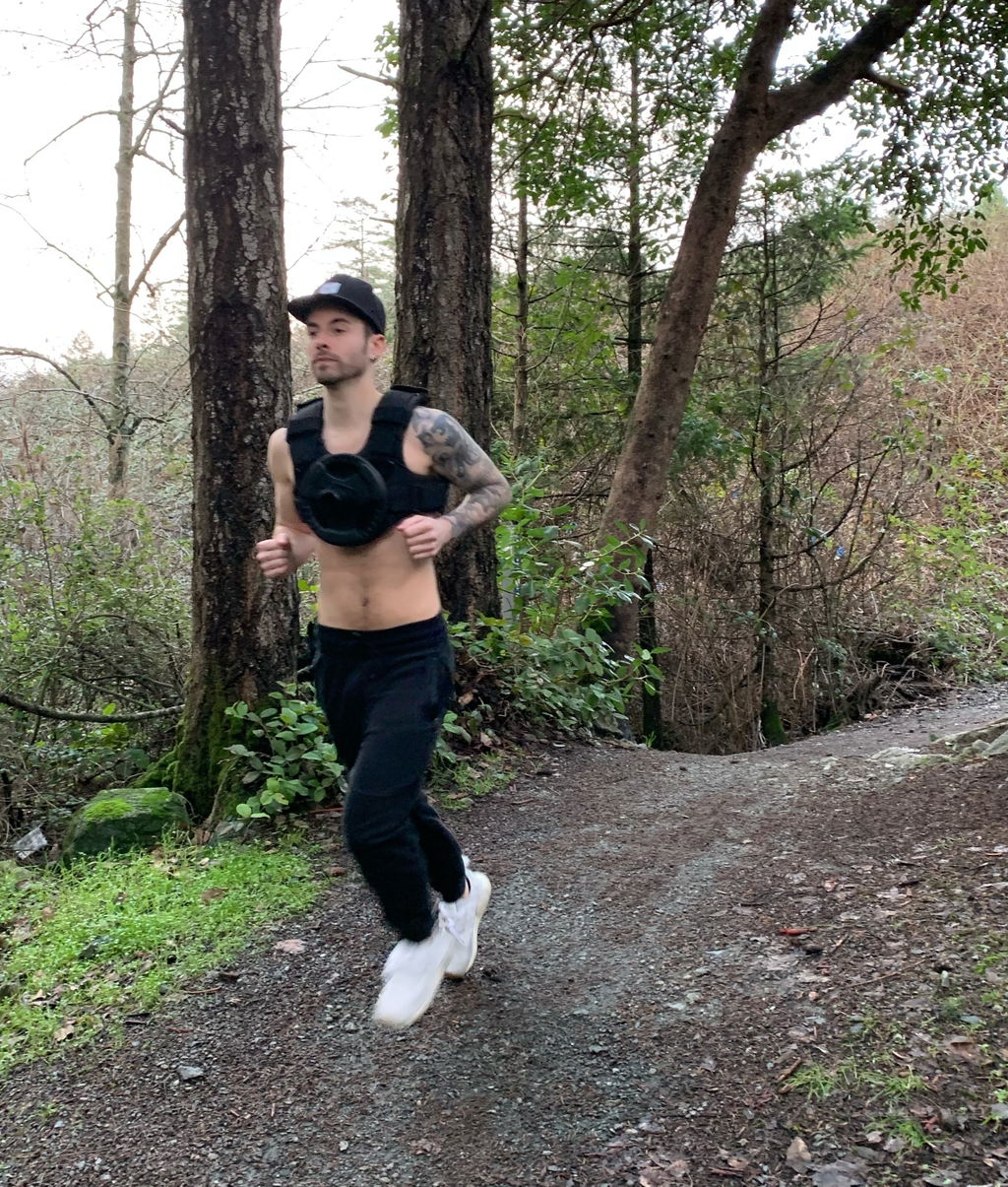 Runner on a wooded trail wearing a weight vest
