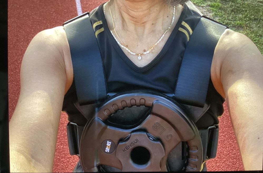 A woman on a running track wearing an EZ-VEST with one plate on the chest