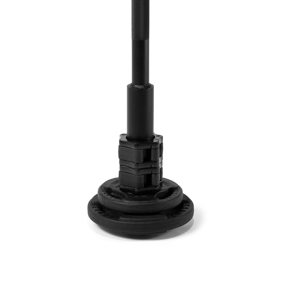 A black plate-loaded club standing upright on a stack of black weight plates, a collar locking the plates to its sleeve